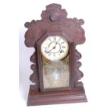 An early 20th century gingerbread type eight-day mantel clock, the chapter ring showing Roman