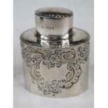 A late Victorian silver tea canister of oval form having embossed floral and C-scrolling decoration,