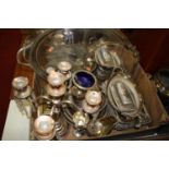 A box of miscellaneous metal wares to include silver plated twin handled serving tray, pair of brass