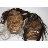 A 20th century Swiss carved pine witch mask, h.29cm; together with one other similar (2)