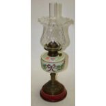 A late 19th century brass oil lamp, the clear glass shade with wavy rim above a painted green opaque