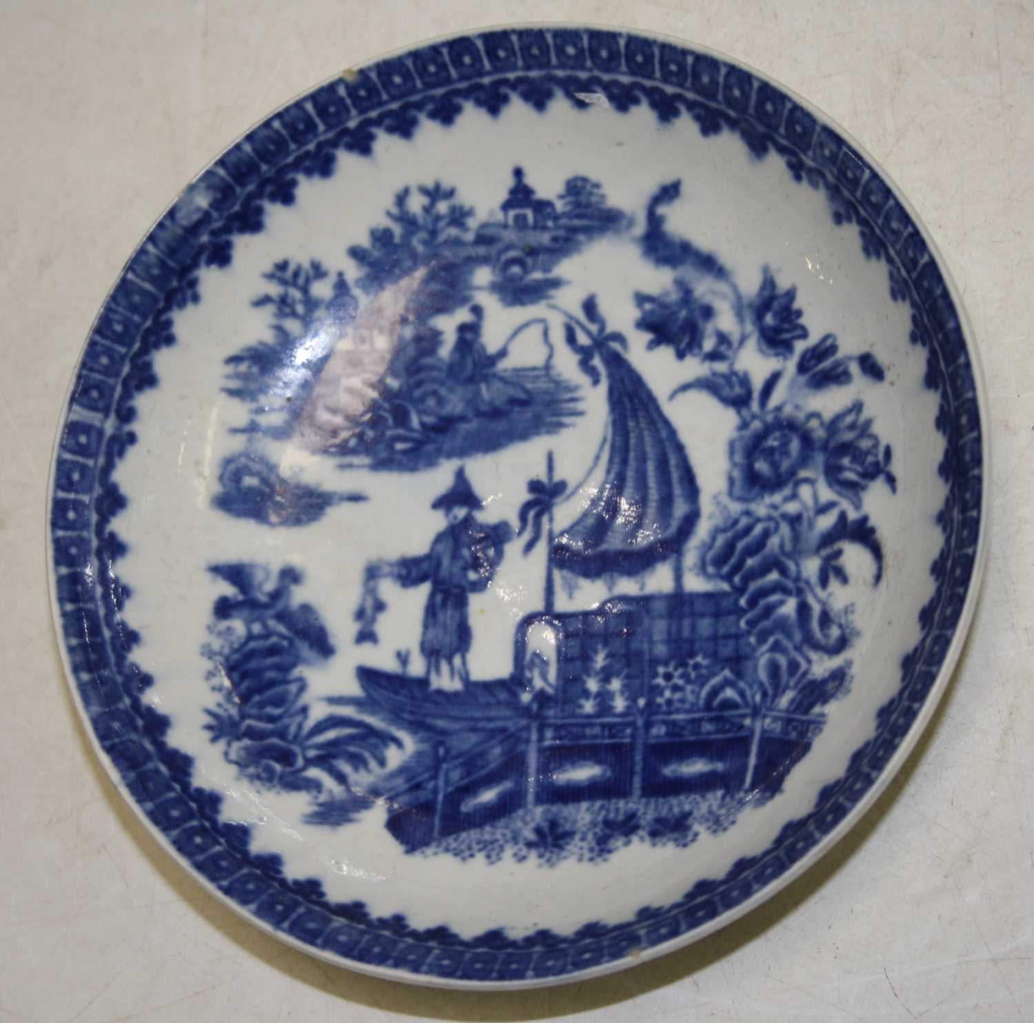 An 18th century Worcester porcelain bowl underglaze blue decorated with a Chinese figure on a junk