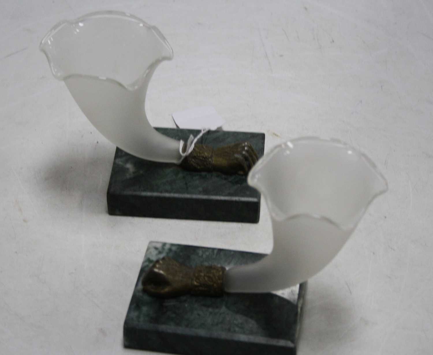 A pair of frosted glass cornucopia vases, each having a shaped bowl with a bronzed metal fist