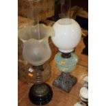A late Victorian brass oil lamp, the wrythen frosted glass shade with wavy rim above a clear glass