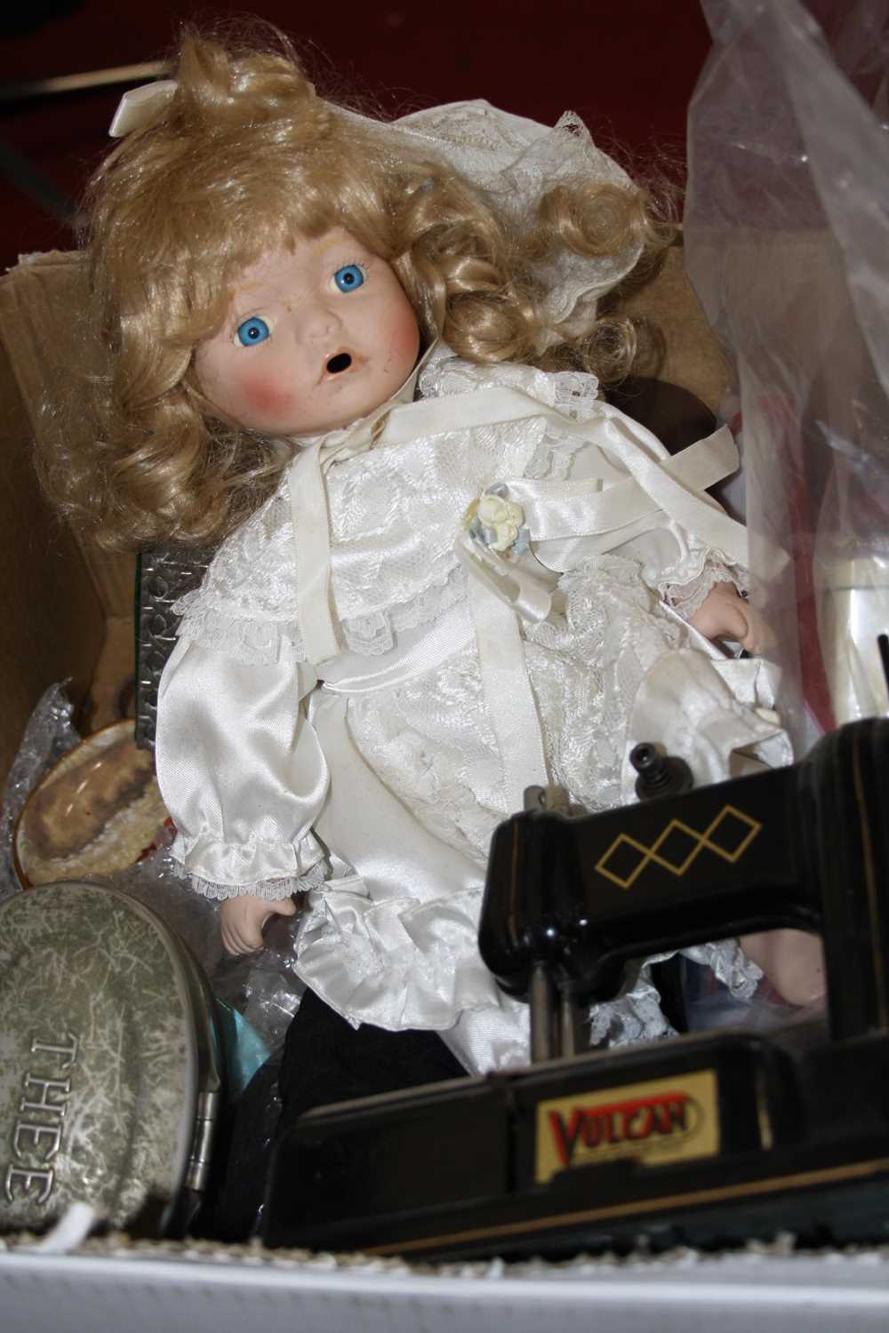 A box of miscellaneous items, to include modern bisque head doll, child's Vulcan tinplate sewing