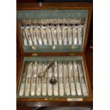 An oak cased set of 12 silver plated fruit knives and forks having mother-of-pearl handles, together