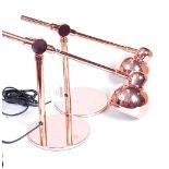 A pair of modern rose-gold coloured metal anglepoise desk lamps, each h.25cm