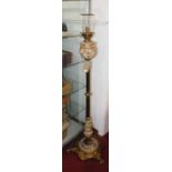 An early 20th century brass standard lamp, converted from oil, the reeded column above a swept