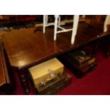 A late Victorian oak extending dining table, having wind-out action, two extra short drop-in leaves,