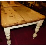 A plank topped pine round cornered long farmhouse kitchen table, raised on painted turned