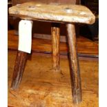 An early 19th century rustic elm three-legged cutlers stool