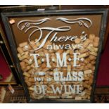 A wall mounted display of wine bottle corks, behind annotated glass, 66 x 46cm