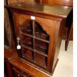 An early 20th century mahogany wall mounted single door glazed curiosity display cabinet, with