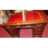 A reproduction mahogany and gilt tooled red leather inset twin pedestal writing desk, width 122cm