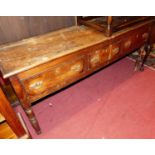 An 18th century elm and fruitwood three drawer dresser base, raised on turned supports (evidence