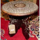 A small Indian floral low relief carved teak circular folding low travel table, dia.29.5cm