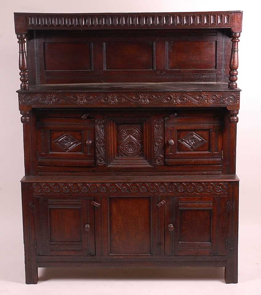 An antique joined oak tridarn, the raised three panel back within turned columns, over two central