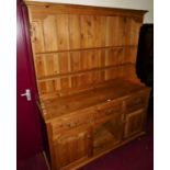 A contemporary pine Welsh kitchen dresser, having two-tier open plate rack over base fitted with