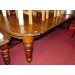 A mid-Victorian oak round cornered extending dining table, having wind-out action, single extra
