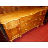 A Victorian serpentine front pine sideboard, having three frieze drawers over twin central long