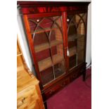 An early 20th century mahogany and flame-mahogany double door astragal glazed bookcase, raised on