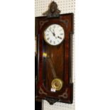 A French walnut droptrunk wall clock, having white enamel dial, glazed trunk door, with pendulum and