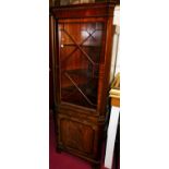 A contemporary mahogany freestanding corner cupboard with single astragal glazed upper door,