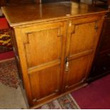 A 1920s oak double door office side cupboard, the interior enclosing six pull-out slides with