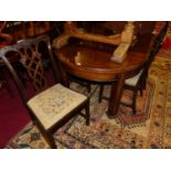 An early 20th century mahogany D-end extending dining table, having wind-out action and two extra