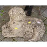 A reconstituted stone garden ornament in the form of a recumbent dog, length 50cm