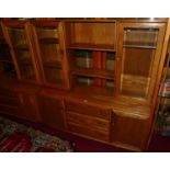 An Ercol elm Windsor range wall cabinet, the modular upper section having twin glazed doors, open