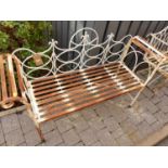 A contemporary painted wired metal hinged folding two-seater garden bench having scroll arms,