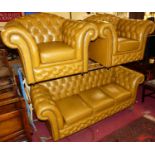 A contemporary leather buttoned upholstered Chesterfield suite, comprising three-seater sofa, w.