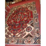 An Iranian red ground woollen carpet with trailing tramline borders, cut down and with repairs,