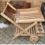 A contemporary teak two-tier X-framed garden potting-up trolley