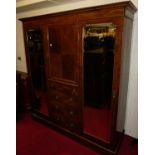 An Edwardian mahogany and satinwood strung triple wardrobe, having central cupboard door over four