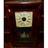 A circa 1900 American flame mahogany drop trunk wall clock, the glazed trunk door depicting