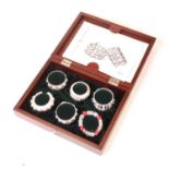 A boxed set of six white metal Omani napkin rings, each a miniature replica of an anklet or bangle