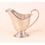 A George V silver cream jug, of helmet shape, maker Barker Brothers Silver Ltd, Birmingham 1928, 7oz