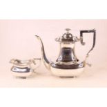 An early 20th century silver coffee pot, having scrolling angular handle, with matching cream jug,