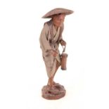 A carved and moulded softwood figure of a gentleman, in standing pose wearing wicker hat, with