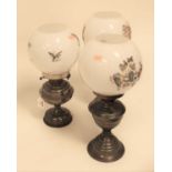 Three various pedestal oil lamps, each having opalescent globular shade with transfer printed