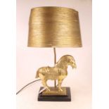 A modern table lamp, surmounted by a brass Trojan type horse, on an ebonised plinth, with shade, h.
