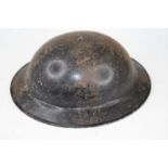 A World War II steel Brodie helmet, having leather liner but lacking chinstrap, marked BMB for