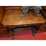 A late 19th century heavily carved oak single drawer hall table, raised on twin turned baluster