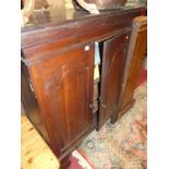 An antique joined oak double door side cupboard, enclosing shelves and raised on oversized bracket