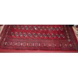 A Persian woollen red ground Bokhara rug, having tasselled ends, 187 x 121cm