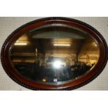 An early 20th century mahogany framed oval bevelled wall mirror, having a gadrooned edge, 72 x 102.