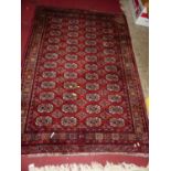 A Persian woollen red ground Bokhara rug, 190 x 131cm