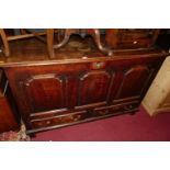 An 18th century joined oak three-panelled hinge topped mule chest, having twin short lower